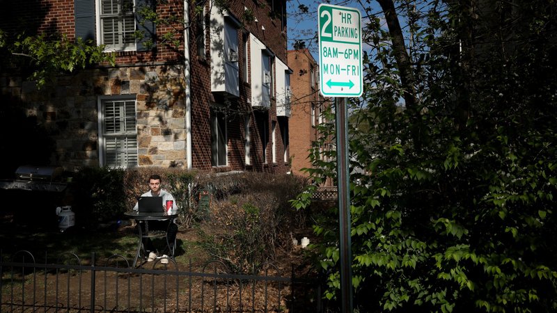 A man in Arlington, Va., uses his laptop outside April 15, 2020, during the coronavirus pandemic. Because of the health crisis, the Fellowship of Catholic University Students has temporarily shifted its outreach online as it continues its mission to support students, chaplains, alumni and benefactors. (CNS photo/Tom Brenner, Reuters)