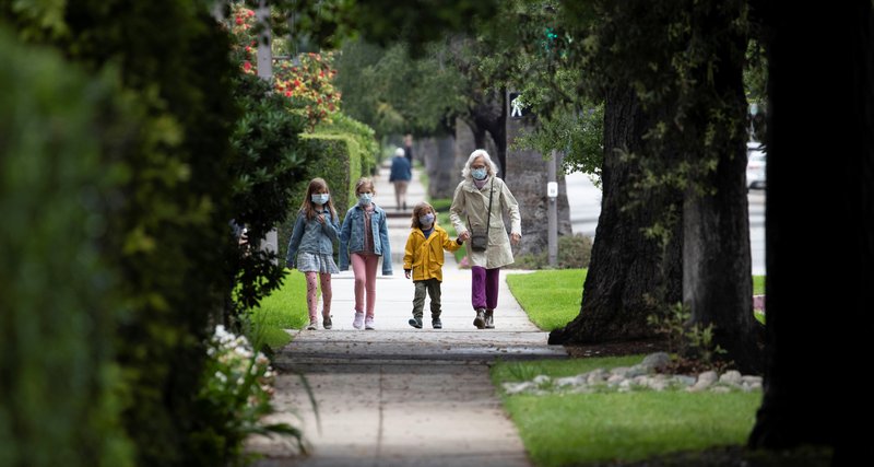 A family in Pasadena, Calif., goes for a walk April 13, 2020, during the coronavirus pandemic. During the stay-at-home orders of the COVID-19 pandemic, many parents are developing creative methods to continue the religious education of their children. (CNS photo/Mario Anzuoni, Reuters)