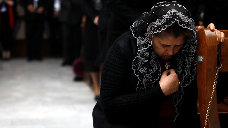A woman prays during Mass in 2019 at St. George Chaldean Church in Baghdad. Stephen Rasche, an American lawyer instrumental in aiding Iraqi Christians suffering from attacks by the Islamic State group, said Christians remain a vital part of Iraq's diverse society, despite their diminishing numbers. (CNS photo/Khalid al Mousily, Reuters)
