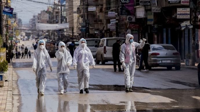 Medical workers oversee the disinfection of the streets to prevent the spread of coronavirus in Qamishli, Syria, Tuesday, March 24, 2020. (Baderkhan Ahmad/AP via Crux)