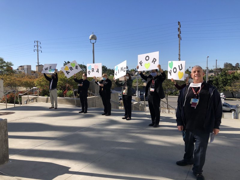 Chaplains at Los Angeles County+USC Medical Center pray outside the hospital April 15. Sometimes, staff inside come to the windows to join them. (Stephanie Ramos)