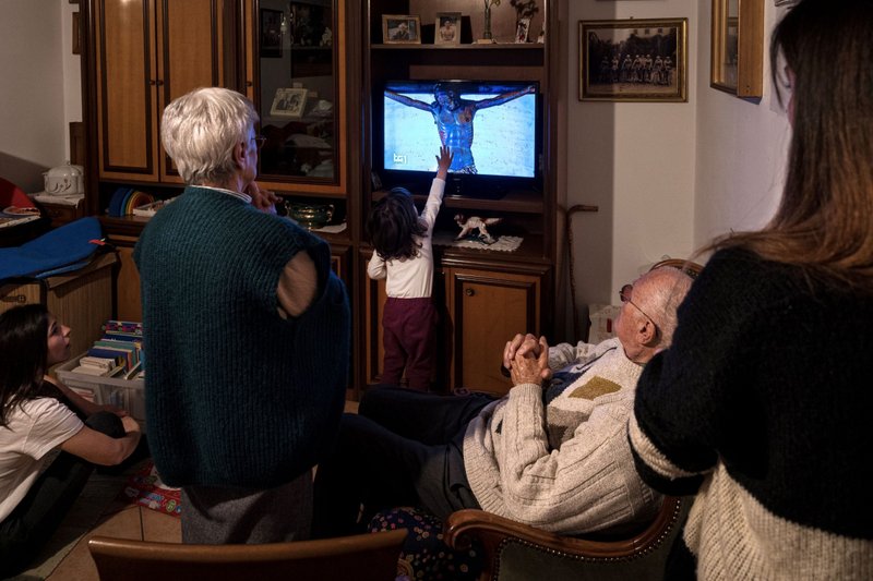 A family watches Pope Francis' "urbi et orbi" ("for the city and for the world") prayer service and blessing on TV together March 27. (Marzio Toniolo/Catholic News Service, Reuters)