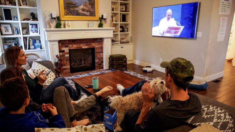 The McClenahan family of Seattle watch Pope Francis' special prayer from the Vatican during the "stay home, stay healthy" initiative March 27, 2020. (CNS photo/Jason Redmond, Reuters)