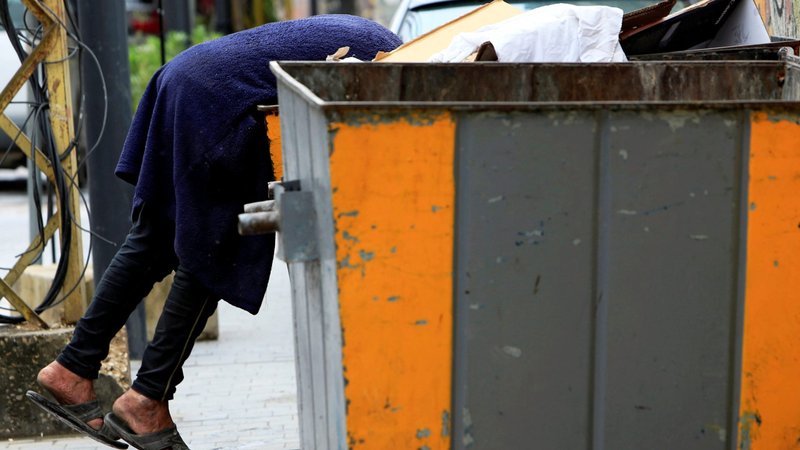 A man searches through a dumpster in Sidon, Lebanon, April 1, 2020. Lebanon's Maronite Catholic Church is drawing up a comprehensive social assistance and food aid plan to help needy families as more Lebanese slide into poverty amid the country's financial collapse. (CNS photo/Ali Hashisho, Reuters)