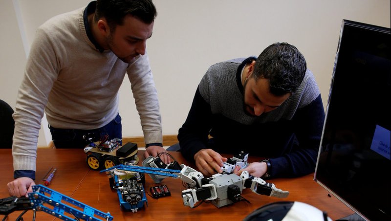 Research support officers and doctoral students Luca Bondin and Foaad Haddad discuss an artificial intelligence project to train robots to autonomously carry out various tasks at the Department of Artificial Intelligence in the Faculty of Information Communication Technology at the University of Malta in Msida, Malta, Feb. 8, 2019. The Vatican's Pontifical Academy for Life is fostering ethics and multidisciplinary alliances in the AI debate. (CNS photo/Darrin Zammit Lupi, Reuters)