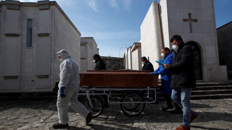 Funeral service workers transport a coffin of a victim of COVID-19 during a ceremony in the southern town of Cisternino, Italy, March 30, 2020. The need for social distancing during the coronavirus pandemic is making the grieving process more difficult for those losing loved ones to the disease. (CNS photo/Alessandro Garofalo, Reuters)