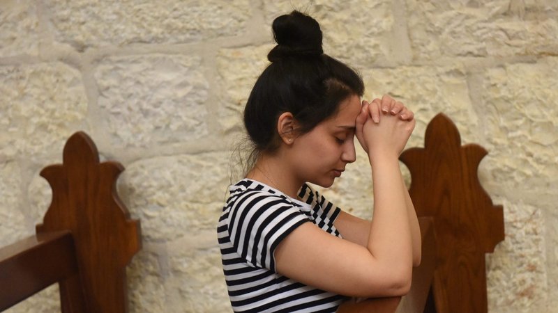 A woman prays during Mass in St. Catherine Church in Bethlehem, West Bank, May 26, 2020, the day the church reopened after being closed during the COVID-19 pandemic. (CNS photo/Debbie Hill)
