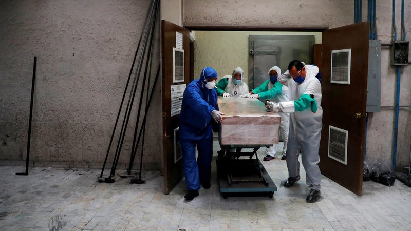 Funeral and crematorium employees push a coffin carrying a victim of COVID-19 at San Isidro crematory in Mexico City May 21, 2020. (CNS photo/Carlos Jasso, Reuters)