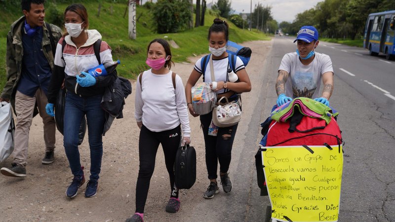 Venezuelan migrants carrying their belongings walk along a highway leading out of Bogota, Colombia, in early April, during the COVID-19 pandemic. The migrants had no money for bus fare and were making a 400-mile trek toward the Venezuelan border. (CNS photo/Manuel Rueda)