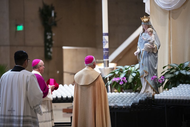 Archbishop José H. Gomez and Bishop Kevin Vann, from the Diocese of Orange, pray before a statue of the Blessed Virgin Mary at the Cathedral of Our Lady of the Angels May 1. (Victor Alemán)