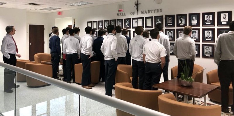 Honors Latin American history teacher Juan Vazquez teaches his students about the Wall of Martyrs located inside the Belen Jesuit Preparatory School administration building. (Image via Facebook @BelenJesuitMiami)