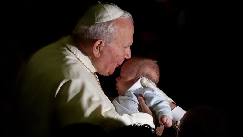 St. Pope John Paul II kisses a baby during a General Audience at the Vatican in 2001. (Catholic News Service/Paolo Cocco, Reuters)