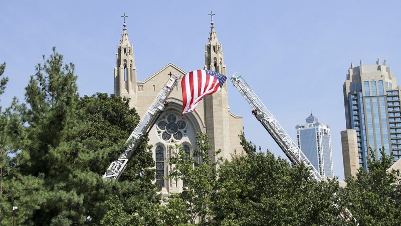 Fire rescue ladders raise the American flag outside the Cathedral of Christ the King in Atlanta where the annual Blue Mass was celebrated. (CNS photo/David Pace, Georgia Bulletin)
