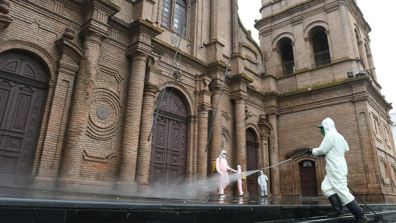 Workers in protective gear clean in front of Metropolitan Cathedral in Santa Cruz, Bolivia, March 26, 2020, amid the coronavirus pandemic. (CNS photo/Rodrigo Urzagasti, Reuters)