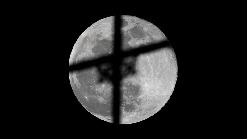 The supermoon, the biggest full moon of 2020, rises behind a cross atop a church May 7 in Karachi, Pakistan. (CNS photo/Akhtar Soomro, Reuters)