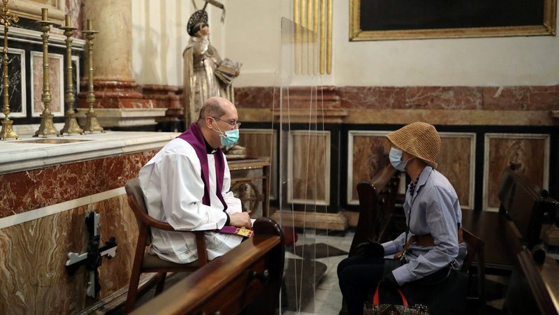 A priest hears confession inside the cathedral in Valencia, Spain, May 19, 2020, as parts of the country relax restrictions during the COVID-19 pandemic. (CNS photo/Nacho Doce, Reuters)