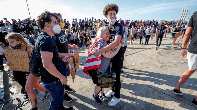 A woman in Minneapolis is comforted after a tanker truck drove into thousands of protesters marching on I-35 West May 31, 2020. Demonstrations continue after a white police officer in Minneapolis was caught on a bystander's video May 25 pressing his knee into the neck of George Floyd, an African American, who later died at a hospital. (CNS photo/Eric Miller, Reuters)