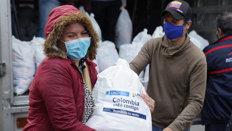 A Venezuelan migrant gets a free food package outside of Our Lady of Lourdes Church in Bogota, Colombia, May 29, 2020. Migrants have been hit hard economically by Colombia's COVID-19 lockdown as they lose their jobs and struggle to pay rent. (CNS photo/Manuel Rueda)