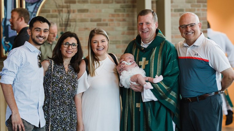 Father Tim Mazur of St. John Vianney Parish in Shelby Township, Mich., poses for a photo with a family in this undated photo. Over the next two years, the Archdiocese of Detroit will transition to a new pastoral and governance model for its 218 parishes called "families of parishes," Archbishop Allen H. Vigneron announced May 31, 2020, the feast of Pentecost. (CNS photo/Naomi Vrazo, Detroit Catholic)