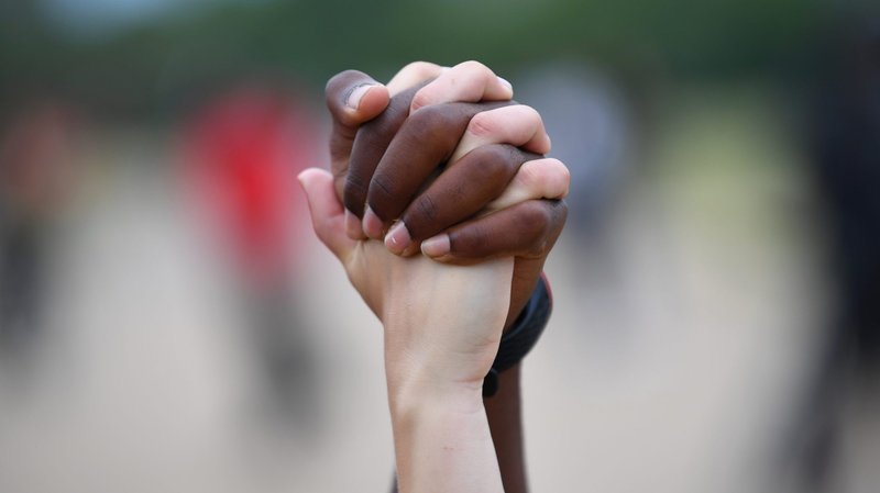A man and woman hold hands in London's Hyde Park during a "Black Lives Matter" protest June 3, 2020, following the death of George Floyd, an African American man who was taken into custody by Minneapolis police and later died at a Minneapolis hospital. (CNS photo/Dylan Martinez, Reuters)