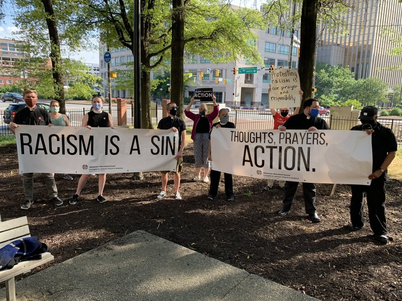 Members of Maryland Lutheran churches hold up banners calling for action against racism during an interfaith prayer vigil in Baltimore June 3, 2020, to pray for justice and peace following the May 25 death of George Floyd -- an unarmed black man said to have spent several minutes under a Minnesota police officer's knee before becoming unconscious. (CNS photo/Tim Swift, Catholic Review)