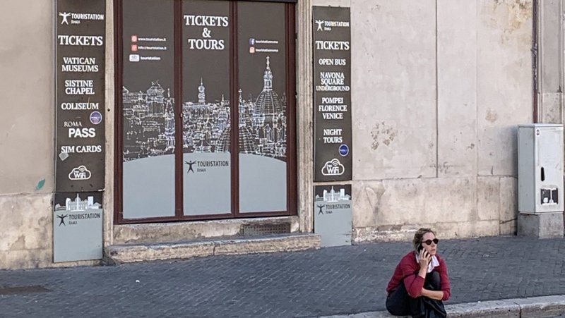 A woman speaks on the phone in front of a shuttered tourist agency in Rome's famous Piazza Navona June 1, 2020. Pope Francis has created a fund to help those left struggling economically in Rome in the wake of the COVID-19 pandemic. (CNS photo/Cindy Wooden)