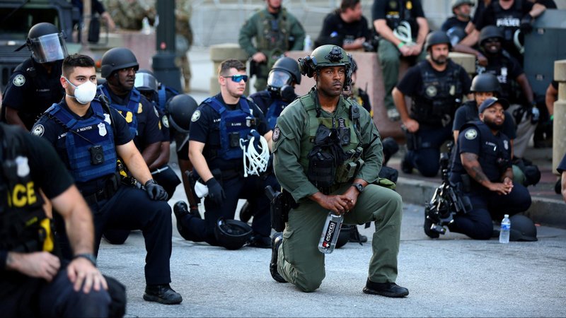 Police officers in Atlanta kneel with protesters June 1, 2020. Demonstrations continue after a white police officer was caught on a bystander's video May 25 pressing his knee into the neck of George Floyd, an African American, who later died at a hospital. (CNS photo/Dustin Chambers, Reuters)