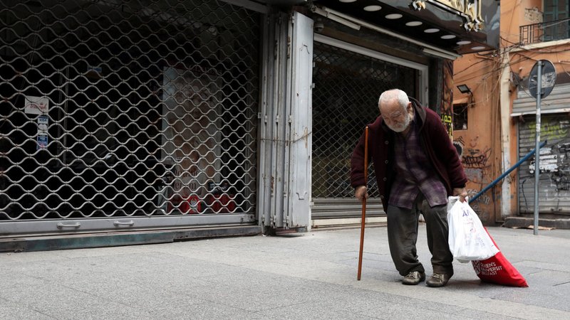 A file photo shows a homeless man walking past closed shops in Beirut during the COVID-19 pandemic. (CNS photo/Mohamed Azakir, Reuters)