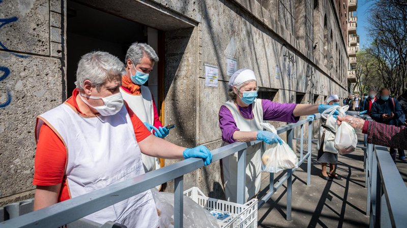 A file photo shows people in need receiving free food outside St. Luke's Parish in Milan during the COVID-19 pandemic. (CNS photo/Marco Passaro, IPA/ABACAPRESS.COM via Reuters)