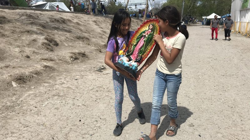 A file photo shows girls carrying a statue of Our Lady of Guadalupe through a tent camp in Matamoros, Mexico. Pope Francis has asked Catholics to add "Comfort of Migrants" and two other titles for Mary to the popular "Litany of Loreto." (CNS photo/David Agren)
