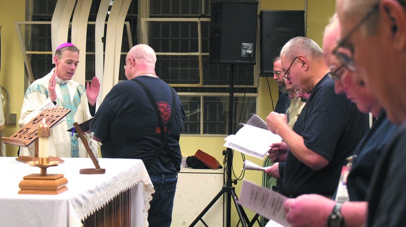 In this 2014 file photo, Archbishop Alexander K. Sample of Portland, Ore., and Hal Elkins are seen together during a Mass in the chapel at Oregon State Penitentiary. (CNS photo/Jon DeBellis, Catholic Sentinel)