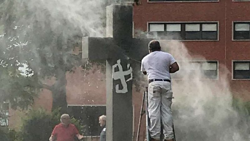 Paint is removed from the central cross at the campus cemetery, Providence College, June 22. (Image courtesy of NBC10/ WJAR via CNA)