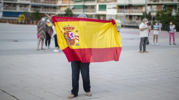 A woman holds a Spanish flag during a protest against the Spanish government amid the lockdown to prevent the spread of coronavirus in Alcorcon, Spain, Friday, May 22, 2020. The Spanish government is allowing Madrid and Barcelona to ease their lockdown measures, which were introduced to fight the coronavirus pandemic. (Credit: Manu Fernandez/AP via Crux)