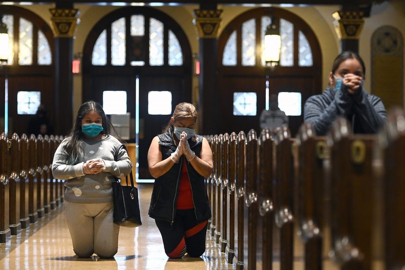 Women wearing protective masks pray inside St. Bartholomew Church in the Queens borough of New York City June 1, 2020, as the United States and other places around the world relaxed restrictions during the COVID-19 pandemic. (CNS photo/Anthony Behar, Sipa via Reuters)