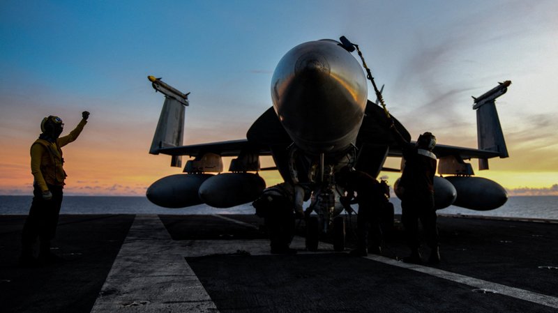 A file photo shows U.S. military personnel working on an F/A-18E Super Hornet as an aircraft carrier conducts drills in the South China Sea. (CNS photo/Mass Communication Specialist 3rd Class Gabriel A. Martinez, U.S. Navy, ABACAPRESS.COM via Reuters)