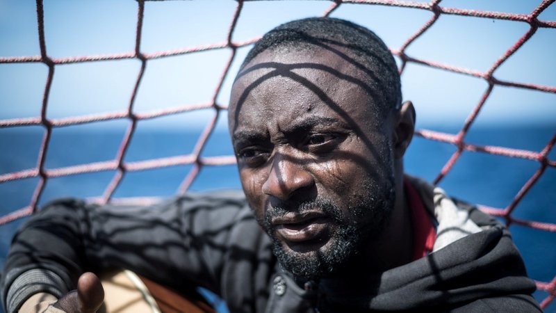 A migrant is seen in a file photo holding his guitar aboard the Sea Watch 3 German charity ship off the coast of Lampedusa, Italy. (CNS photo/Nick Jaussi, Sea-Watch via Reuters)