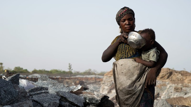 A woman feeds her child at a granite quarry in Ouagadougou, Burkina Faso, in early June, during the COVID-19 pandemic. (CNS photo/Anne Mimault, Reuters)