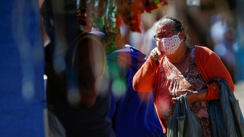 A woman wearing a protective mask gestures on a street in Brasilia, Brazil July 7, 2020, during the COVID-19 pandemic. In Brazil, where the cases as of July 12 totaled more than 1.8 million and over 72,000 deaths, 400 inmates from 23 prisons are producing 350,000 masks to reduce the spread of the coronavirus. (CNS photo/Adriano Machado, Reuters)