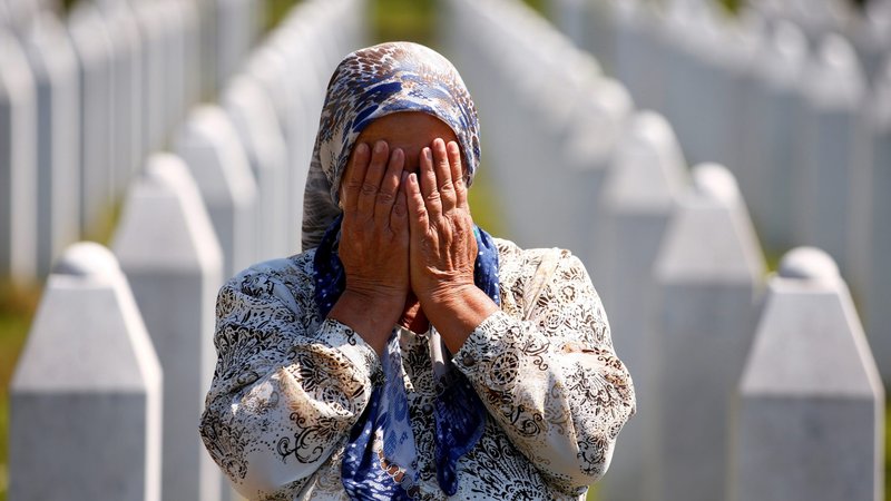 A woman prays at a graveyard in Potocari, Bosnia-Herzegovina, July 11, 2020, during a ceremony marking the 25th anniversary of the Srebrenica massacre, Europe's worst since World War II. (CNS photo/Dado Ruvic, Reuters)