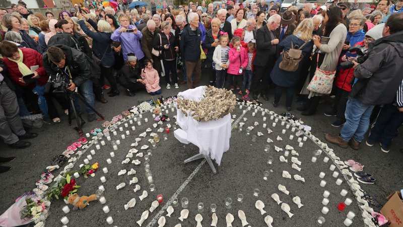 People gather to protest at the site of the former state-funded, Catholic-run home for unmarried mothers in Tuam, Ireland -- where a mass grave of 796 babies was uncovered -- in this 2018 photo. The Vatican ambassador to Ireland has backed the idea that the babies should be reburied in consecrated ground. (CNS photo/Niall Carson, Reuters)
