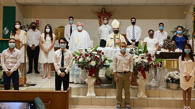 Bishop Daniel E. Flores of Brownsville, Texas, poses for a group photo July 26, 2020, after confirmations at San Felipe de Jesus Parish. A group of 13 Catholic youth received the sacrament of confirmation as parts of Texas were undergoing a hurricane threat amid the coronavirus pandemic. (CNS photo/courtesy Bishop Daniel Flores, Diocese of Brownsville)