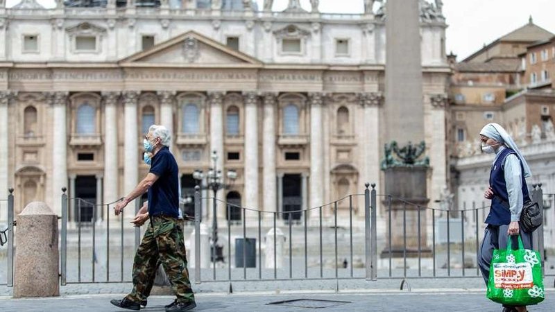 People pass in front of St. Peter's Basilica at the end of May 2020. (Daniel Ibanez/CNA)