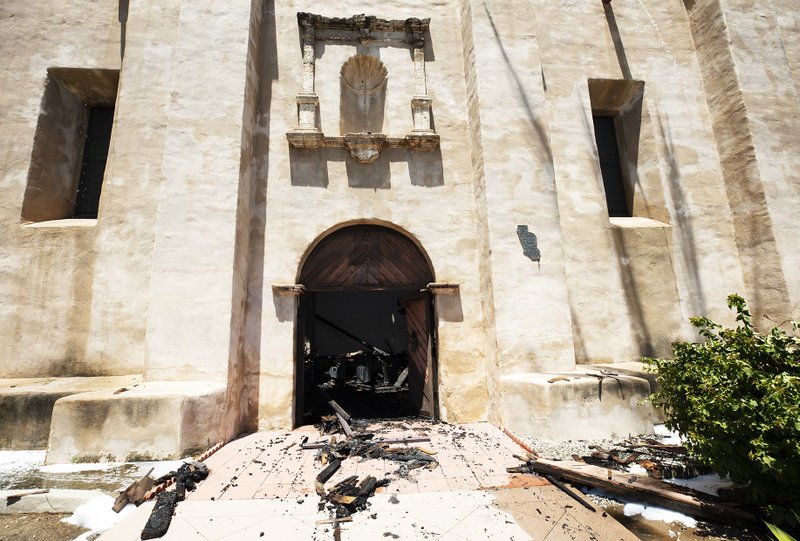 Charred rubble spills out of the church doors. (Victor Alemán/Angelus News)