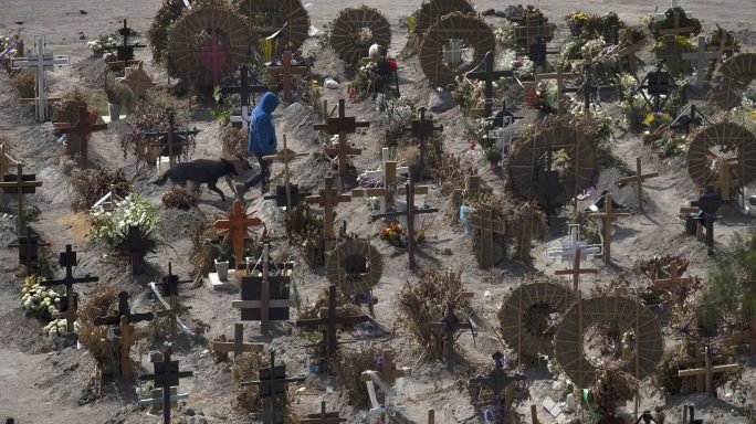 Cemetery foreman Juan Rivera walks with his dogs in the Municipal Cemetery of Valle de Chalco amid the coronavirus pandemic on the outskirts of Mexico City, Monday, June 15, 2020. (Marco Ugarte/AP via Crux)