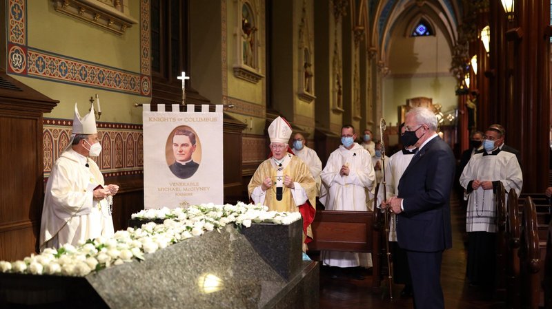 Baltimore Archbishop William E. Lori, supreme chaplain of the Knights of Columbus, left, prays Aug. 4, 2020, at the granite sarcophagus holding the remains of Father Michael McGivney, founder of the Knights of Columbus, at St. Mary's Church in New Haven, Conn. Later at the opening Mass of the Knights' 138th annual Supreme Convention, it was announced a new Blessed Michael McGivney Pilgrimage Center will be created at the current Knights of Columbus Museum in New Haven. (CNS photo/courtesy Knights of Columbus)