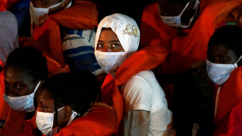 Rescued migrants look out from an Armed Forces of Malta vessel upon their arrival in Valletta, Malta, Aug. 3, 2020. (CNS photo/Darrin Zammit Lupi, Reuters)