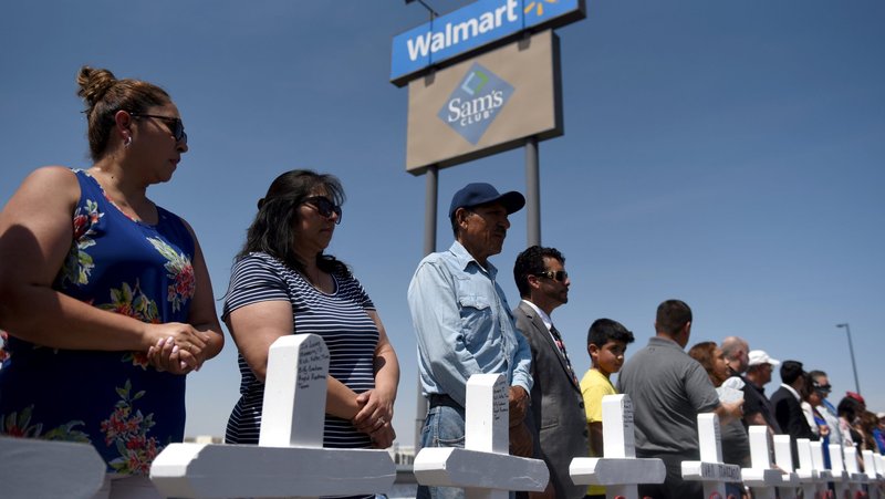 People stand near crosses Aug. 5, 2019, in honor of the victims of a mass shooting Aug. 3 at a Walmart store in El Paso, Texas. In an interview with Catholic News Service, El Paso Bishop Mark J. Seitz reflects about the tragic event a year after the killings that profoundly impacted him and his community. (CNS photo/Callaghan O'Hare, Reuters)