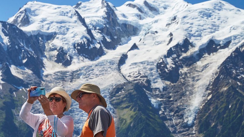 Tourists take a selfie with Mont Blanc in the background in the resort area of Chamonix, France, July 20, 2020, during the COVID-19 pandemic. (CNS photo/Denis Balibouse, Reuters)