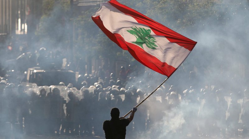 An anti-government protesters waves a Lebanese flag during clashes with security forces in Beirut Aug. 8, 2020. (CNS photo/Goran Tomasevic, Reuters)
