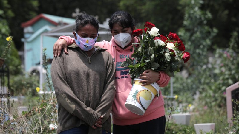 Relatives wearing protective masks react near the coffin of a man during his burial at a cemetery in Mexico City Aug. 6, 2020, during the COVID-19 pandemic. (CNS photo/Henry Romero, Reuters)